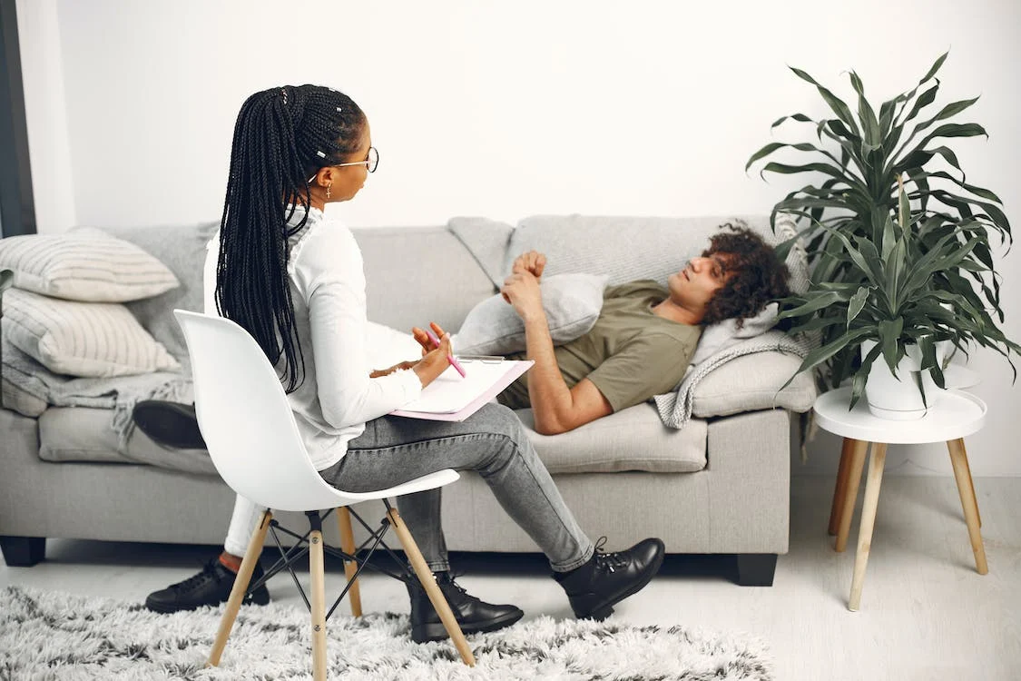 man laying on couch while in a therapy session